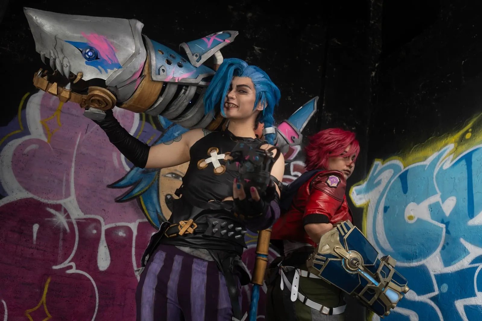 Jinx and Vi duo cosplay from Arcane with fabricated weapon props
